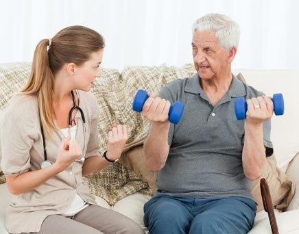 Image Content Older man exercising at home with the help of a caregiver