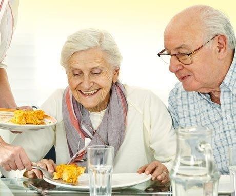 Two senior citizens being served a meal at a Three Rivers area senior center